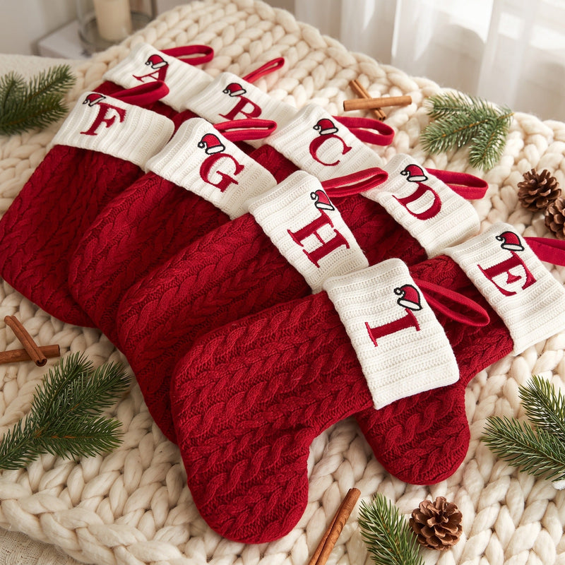 Red knit initial mini stockings with cream cuffs on a knit blanket