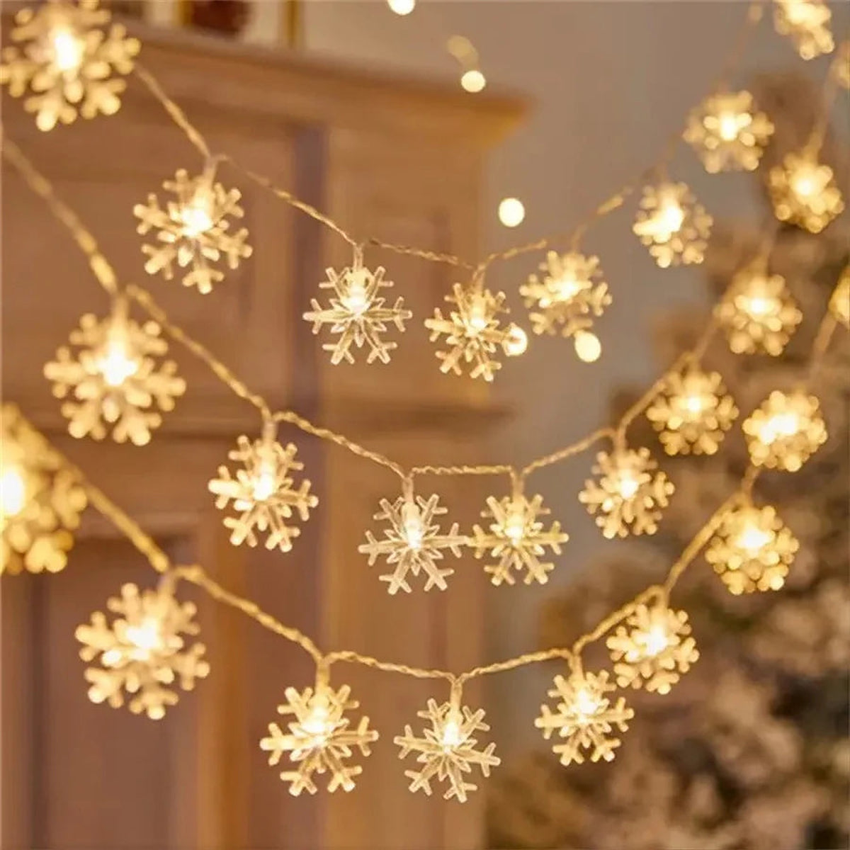 Warm white snowflake string lights draped by a fireplace