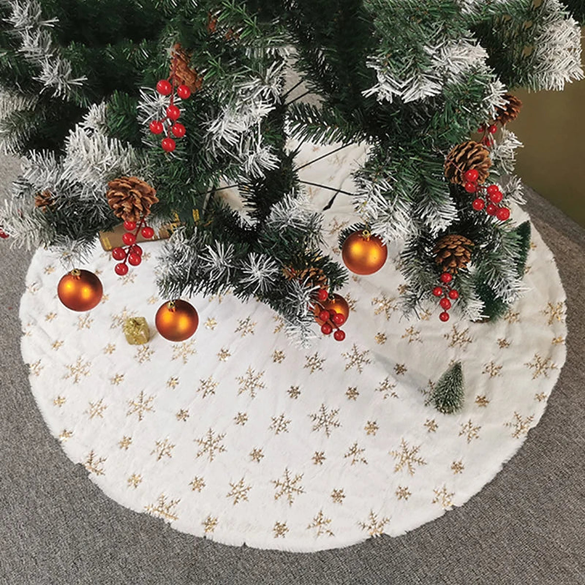 White tree skirt with gold snowflakes under a Christmas tree