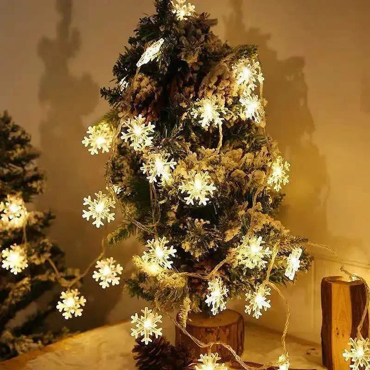 Warm white snowflake lights wrapped around a small Christmas tree