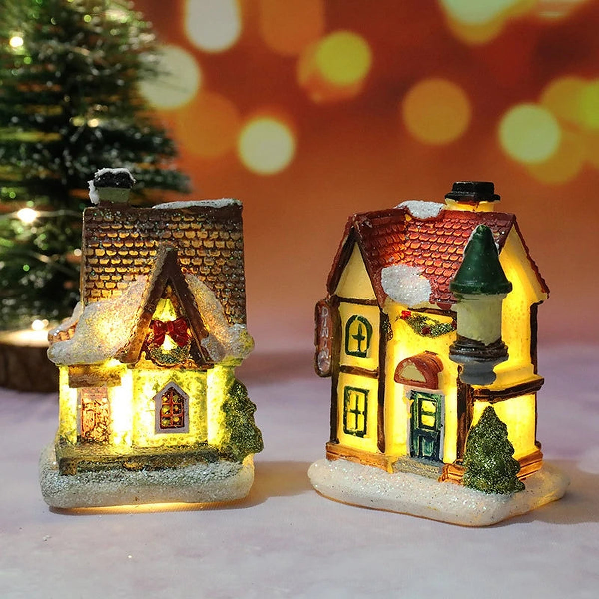 Two light-up village houses: shingle cottage and toy shop