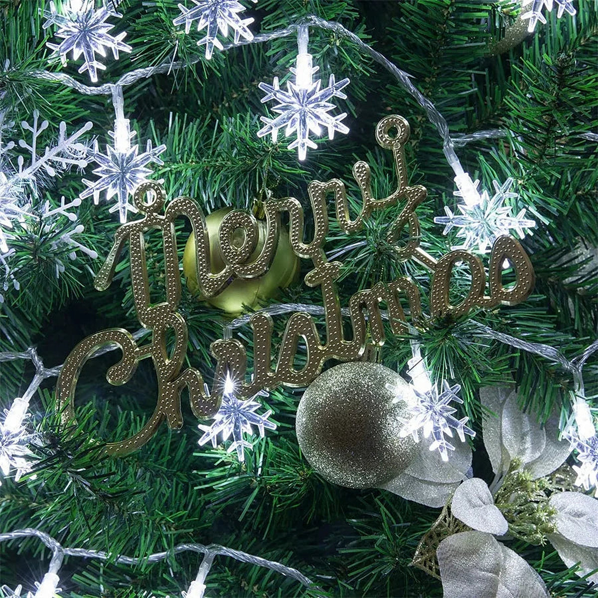Cool white snowflake lights on a Christmas tree with a Merry Christmas sign