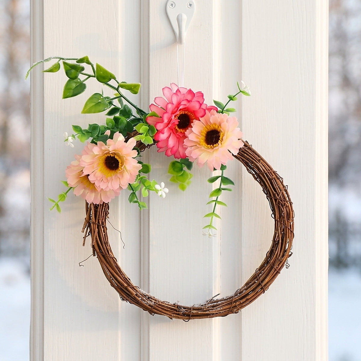 Rattan wreath decorated with pink flowers on a door (decorations not included)