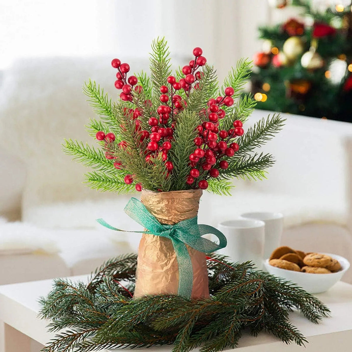 Pine and red berry picks arranged in a vase on a table