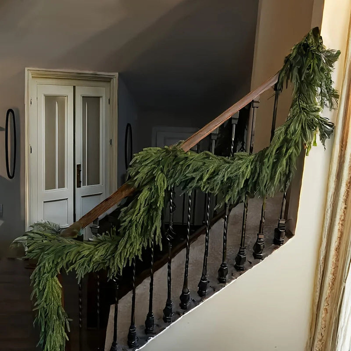 Norfolk pine garland on a staircase banister