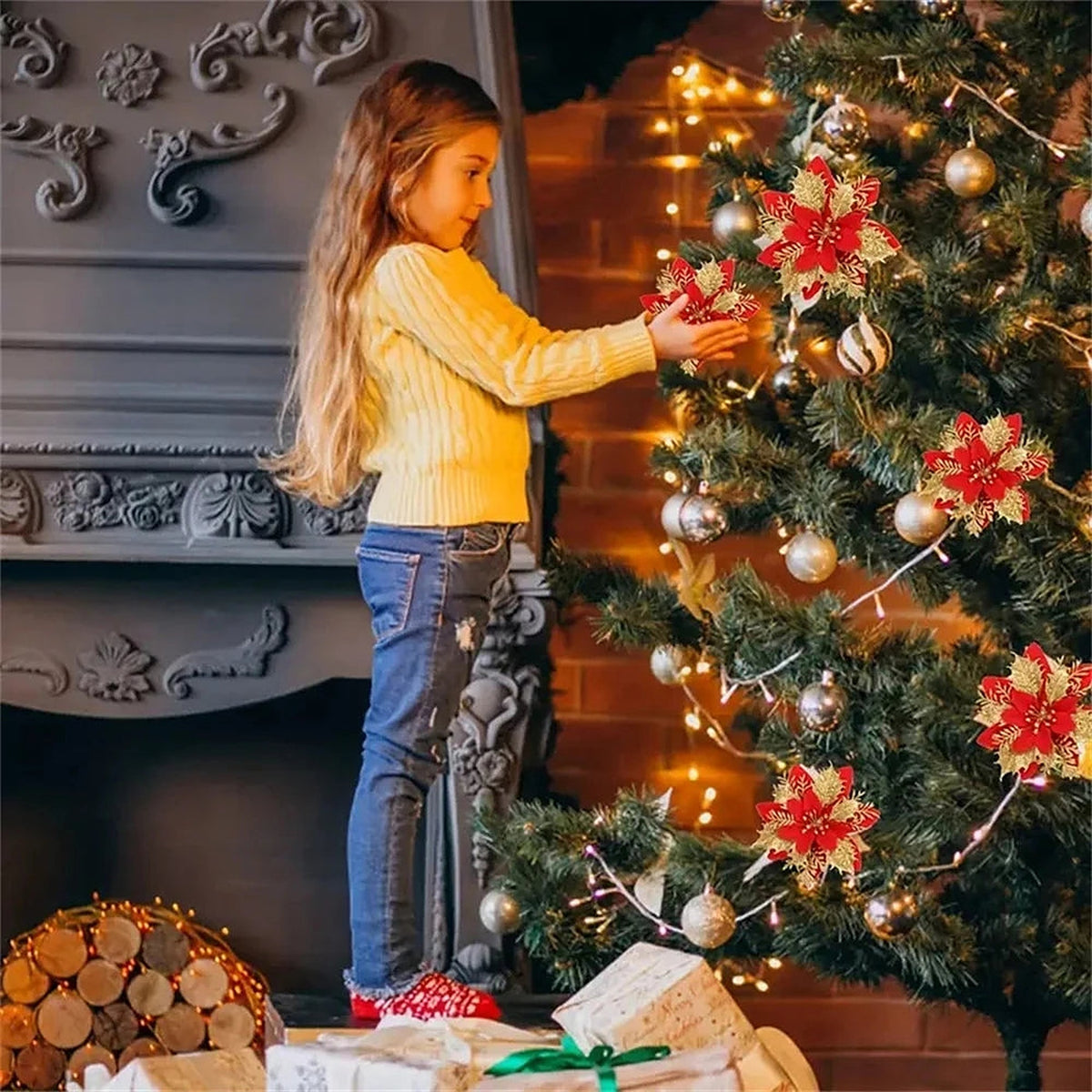 Girl placing red and gold poinsettias on a Christmas tree