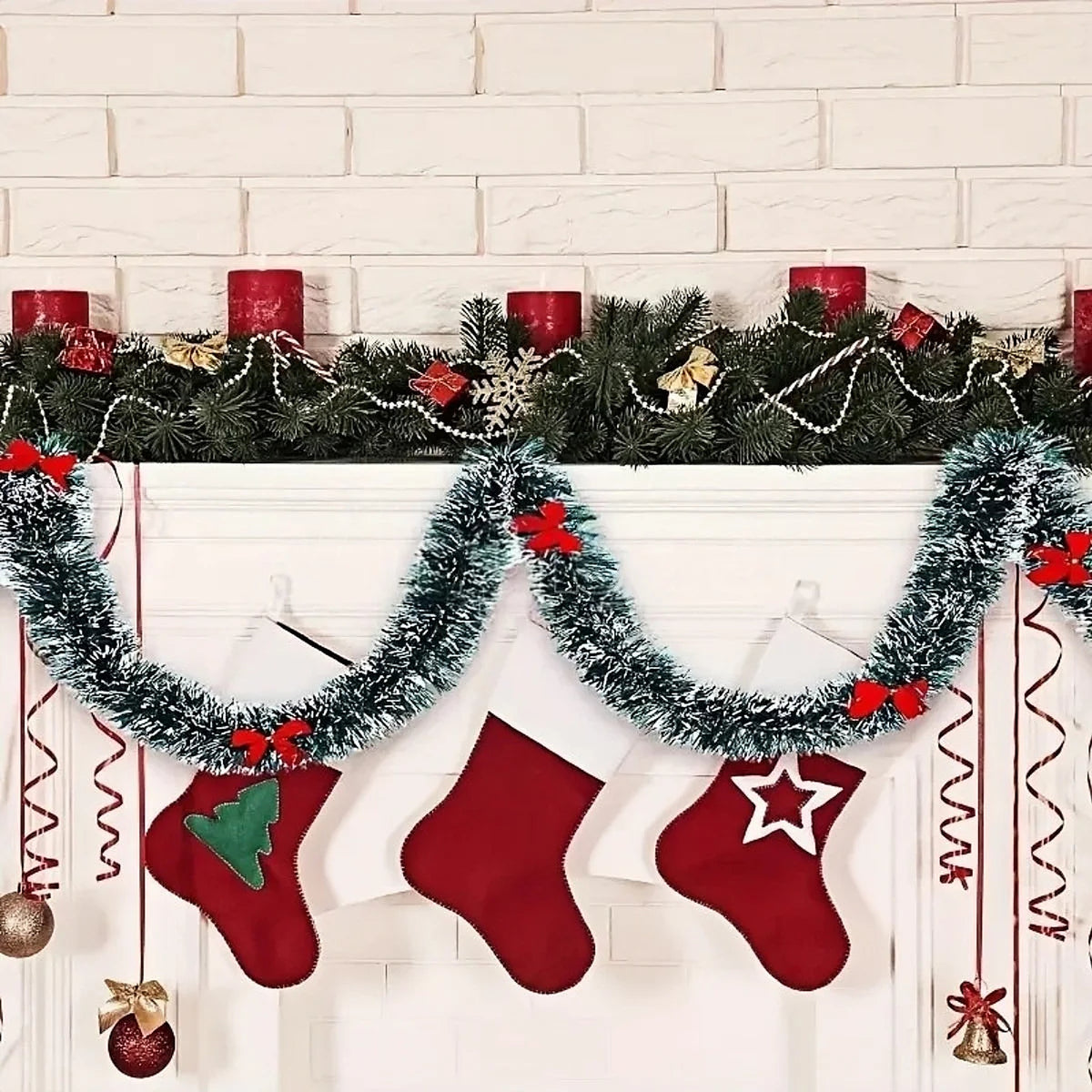 Tinsel garland with red bows draped along a mantel above stockings