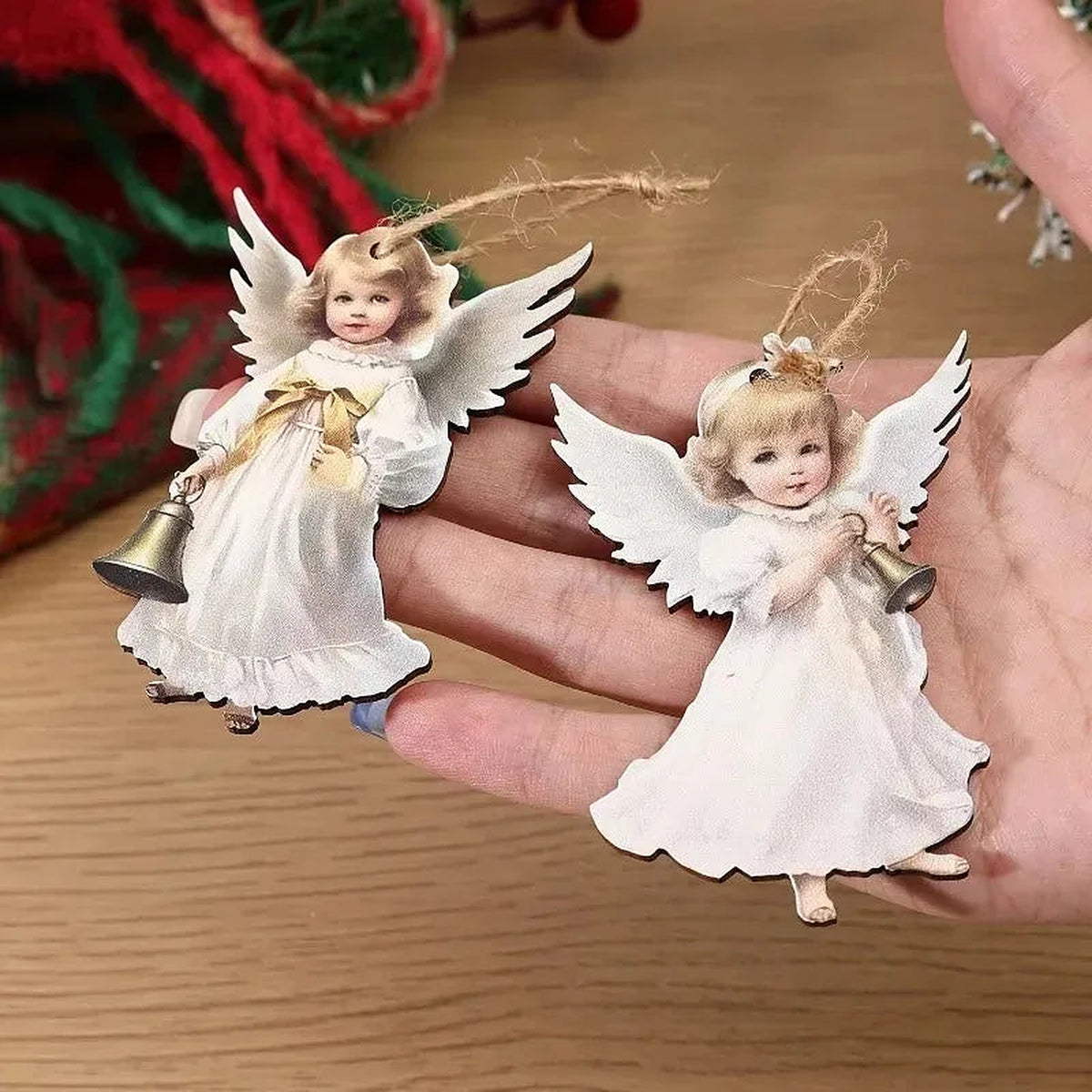 Close-up of two wooden angel ornaments in a hand