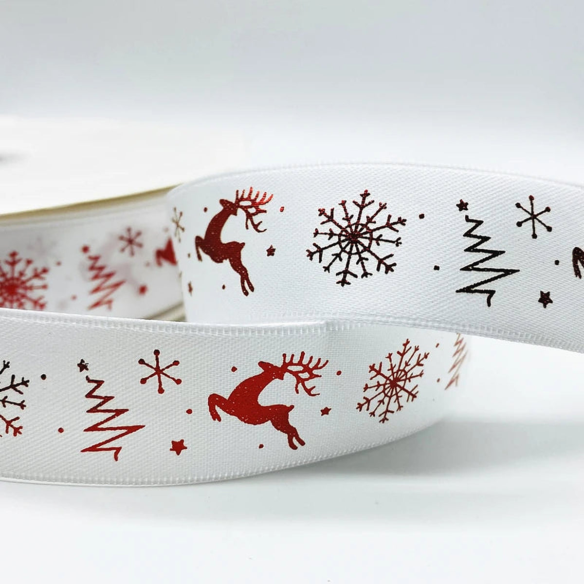 White ribbon with red reindeer, trees and snowflakes