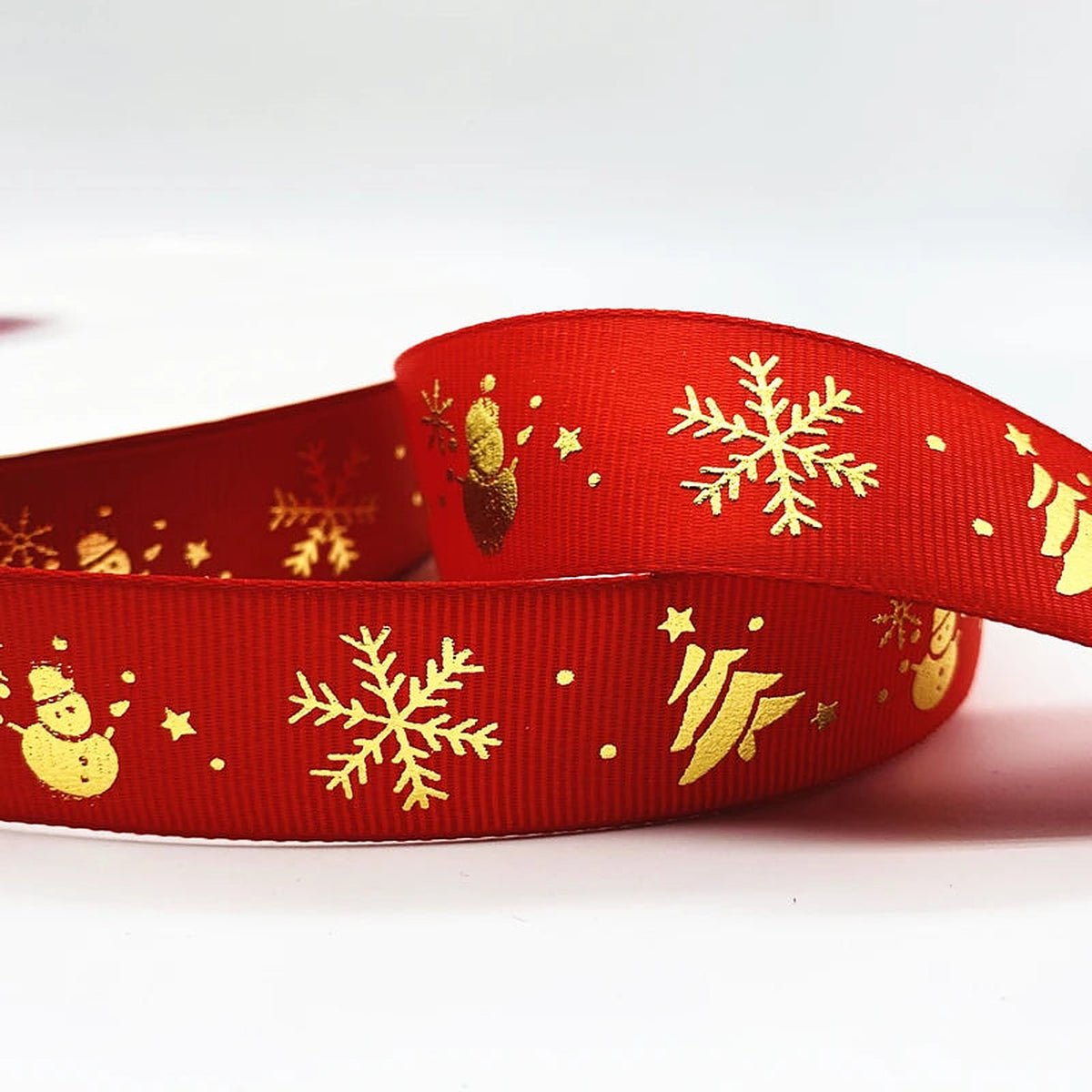 Red ribbon with gold snowman, snowflakes and trees